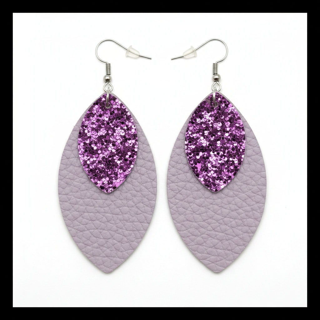 Purple glittery leaf-shaped earrings on gray textured surface